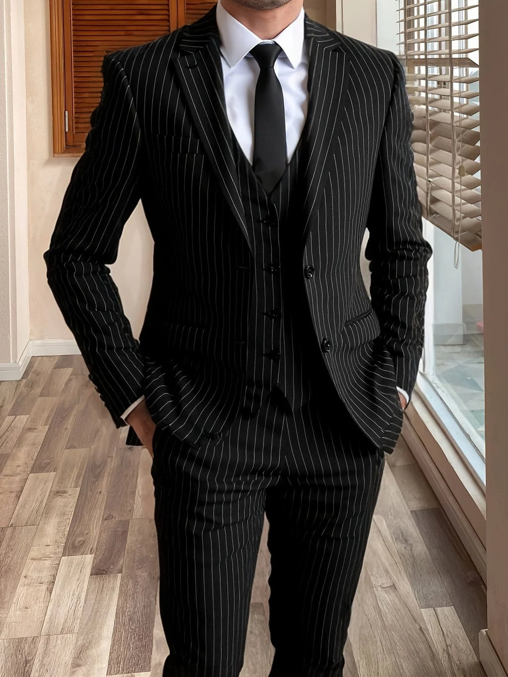 Men's black tailored pinstripe three-piece suit in autumn and winter