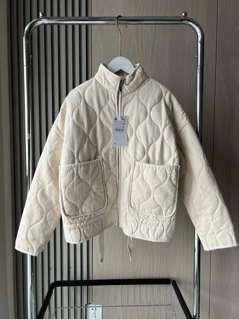 Women's ivory quilted zip-up jacket with welt pockets for layering