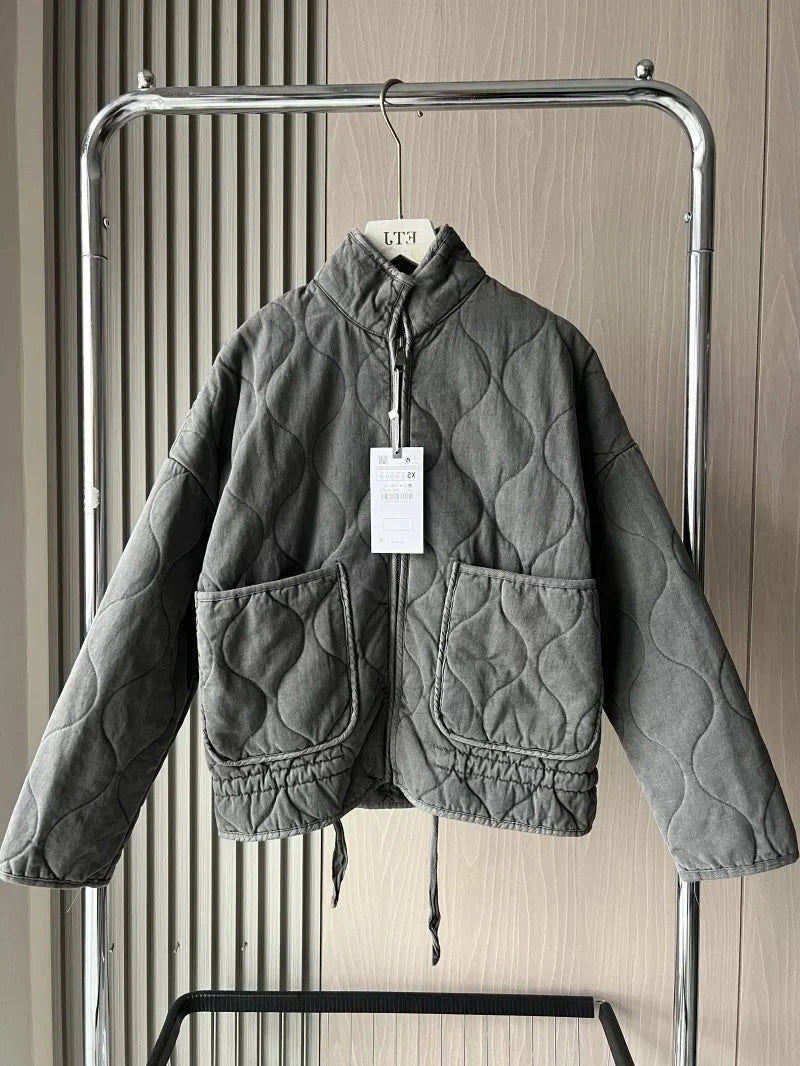 Women's dark grey quilted zip-up jacket with welt pockets for layering