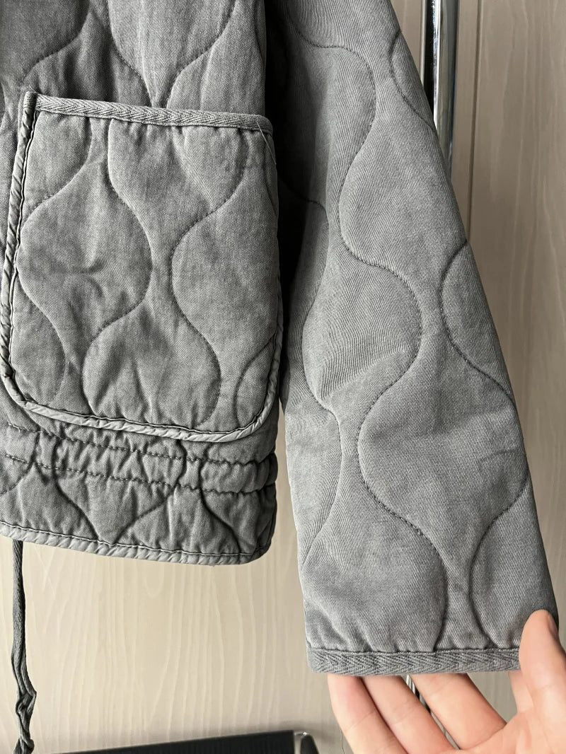 Women's black quilted zip-up jacket with welt pockets for layering